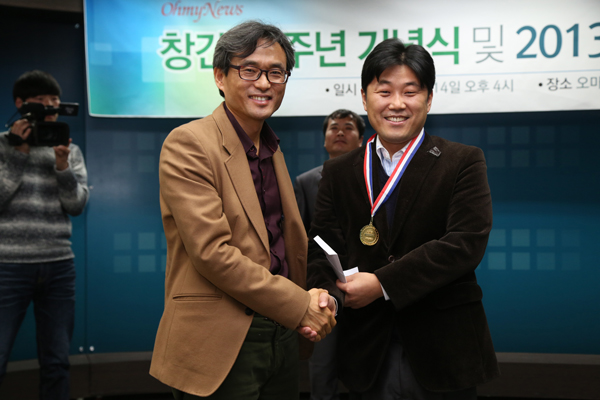 ▲2월14일오마이뉴스오연호대표로부터‘으뜸상’금메달과상금을받고악수하는모습/사진제공=오마이뉴스