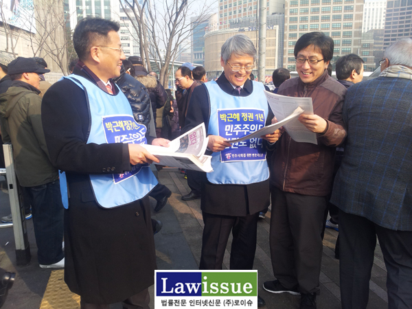 ▲조영선변호사(좌)와장주영회장이시민드에게나눠주는전단지가무엇인지살펴보는김인회민변사법위원장