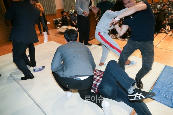 ▲학생들이경찰로부터호신술을배우고있다.