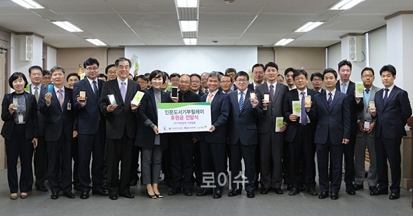 ▲조해현대구지법원장(앞줄우측5번째)등법관들이스마트폰으로인문도서기부앱을내려받아기부금을보내고기념촬영.(사진제공=대구지법)