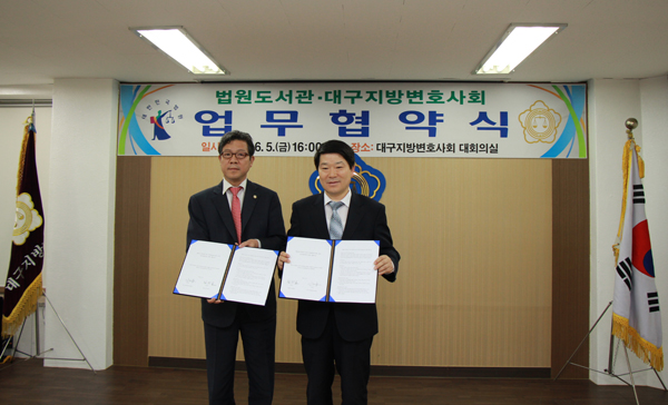 ▲김찬돈법원도서관장(오른쪽)과이재동대구지방변호사회회장이협약문을펼쳐보이고있다(사진=대법원)