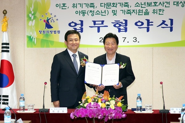▲이강원창원지법원장(사진왼쪽)과안상수창원시장이위기가정지원업무협약서를내보이고있다.
