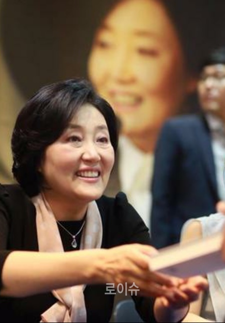▲박영선의원이사인한책을독자에게전달하며활짝웃고있다.