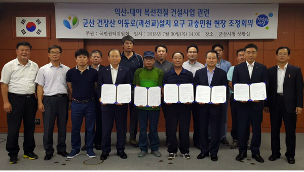 ▲국민권익위원회최학균상임위원이30일군산시건장산주민이동로개설을요구하는집단민원을중재한후관계자들과기념촬영을하고있다.(사진=권익위)