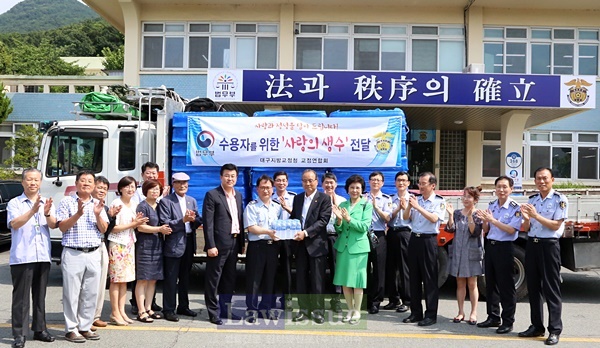이윤희 대구지방교정청 교정연합회장이 김명철 부산구치소장에게 생수를 전달하고 직원들과 기념촬영.