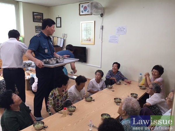 안경찬 산격지구대장이 어르신들에게 음식을 배식하며 대화를 나누고 있다.