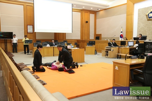 심정지 상태의 피고인에 대해 심폐소생술을 하고 있다.