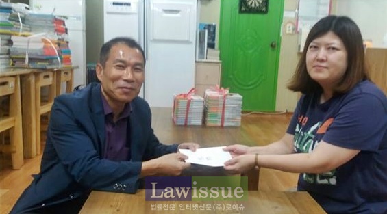 이양근 센터장(왼쪽)이 실로암지역아동센터 곽정현 센터장에게 위문금을 전달하고 기념촬영.