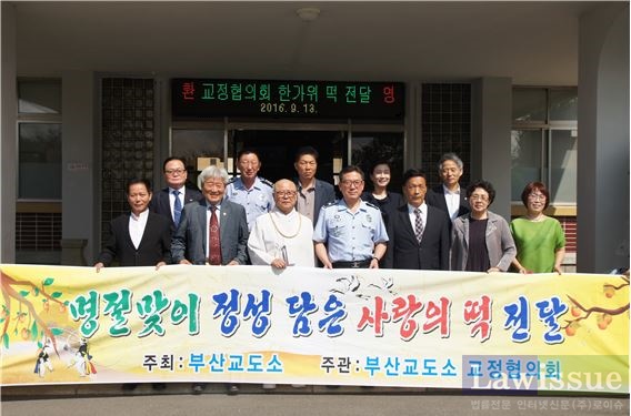 부산교도소교정협의회가 사랑의 떡 전달을 하고 기념촬영.