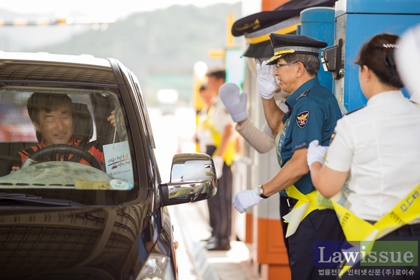 이상식 부산경찰청장이 귀성객들에 졸음패치 등을 제공하고 거수경례로 안전운전을 당부하고 있다.