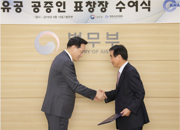 김현웅 법무부장관이 19일 오후 정부과천청사 법무부 대회의실 에서 공증업무에 있어 국민에 대한 법률서비스 향상에 기여한 유정주 공증인에게 표창장을 수여하고 있다.(사진=법무부)