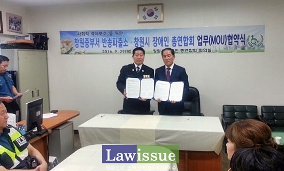 반송파출소와 창원시 장애인총연합회가 업무협약서를 내보이며 기념촬영.