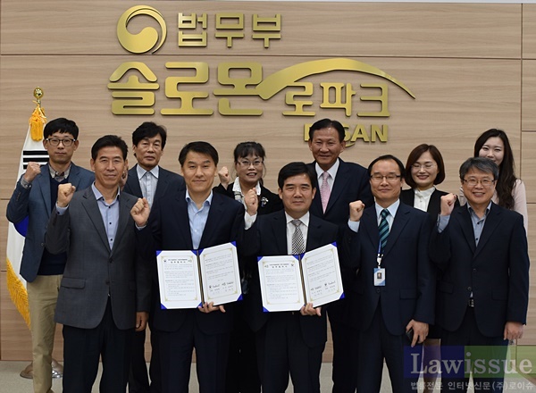 윤일중 소장(앞줄 왼쪽 두번째)과 강정수 관장(왼쪽 세번째)이 업무협약을 체결하고 직원들과 파이팅을 하고 있다.(사진제공=부산솔로몬로파크)