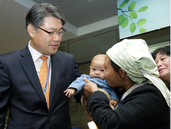 김우현 출입국·외국인정책본부장(가운데)이 2일 오전 인천공항 입국장에서 열린 재정착 난민 입국 환영행사에서 재정착 난민 아이를 바라보고 있다.(사진=법무부)