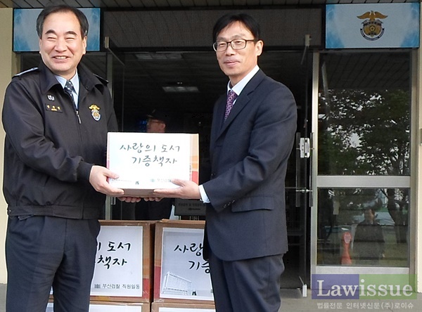 정재열 총무과장이 정병옥 사건과장으로부터 책자를 전달받고 기념촬영.