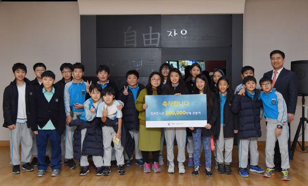 법원전시관 20만번째 관람객인 김보민 학생과 함께 견학온 서울교대 부속초등학교 귀국반 학생들과 대법원 조병구 공보관.(사진=대법원)