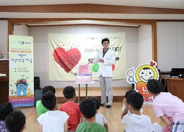 고광욱 유디치과 대표원장이 아이들에게 치아모형을 이용하여 올바른 칫솔질 교육을 실시하고 있다