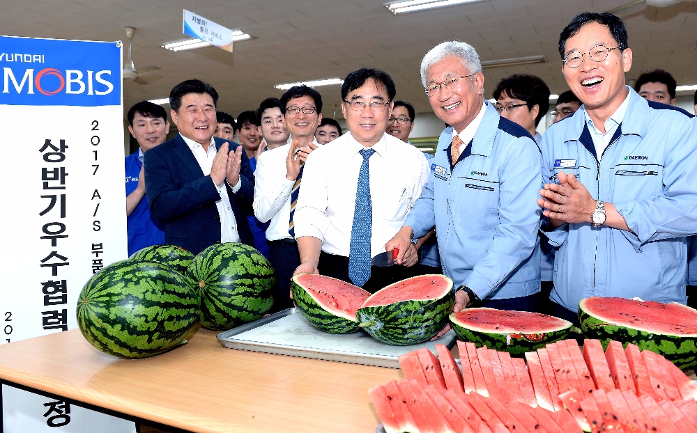 경기도 안산에 소재한 ㈜대원산업에서 현대모비스가 수박을 나누는 모습. 앞 줄 중앙(현대모비스 통합구매담당 조성진 이사), 오른쪽에서 두 번째(대원산업 허재명 대표이사).(제공=현대모비스)