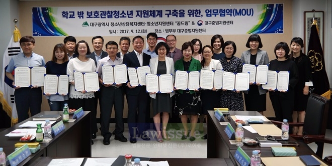 업무협약서를 내보이며 기념촬영을 하고 있다.