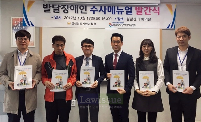 발달장애인 수사매뉴얼 발간식 행사를 갖고 책자를 내보이며 기념촬영.
