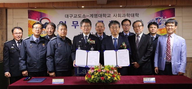 박호서 소장과 김영철 학장이 업무협약서를 내보이며 직원들과 기념촬영.