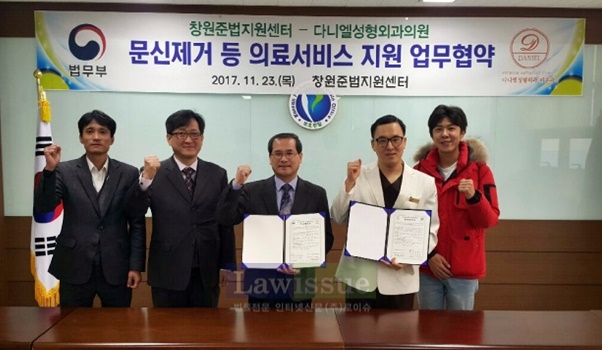 문신제거 등 의료서비스 지원 업무협약서를 내보이며 기념촬영.