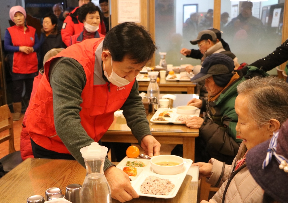 공영홈쇼핑은 8일 서울 마포구 노인종합복지관에서 ‘따뜻한 배식봉사’를 진행했다. 이영필 공영홈쇼핑 대표(왼쪽)가 어르신에게 음식을 담은 식판을 전달하고 있다.(사진=공영홈쇼핑)