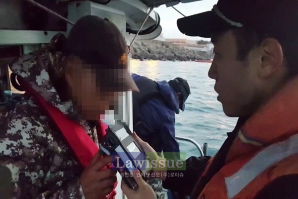 낚시어선 선장을 상대로 음주여부를 측정하고 있다.(사진=울산해양경찰서)