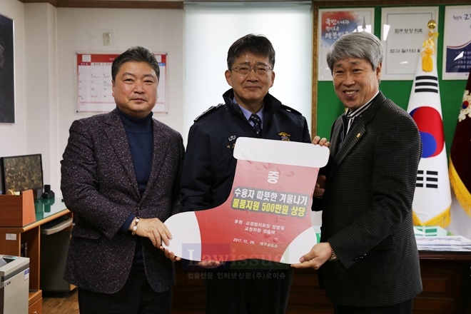 박호서 소장이 교정협의회로부터 후원받은 수면양말을 들고 기념촬영을 하고 있다.(사진=대구교도소)