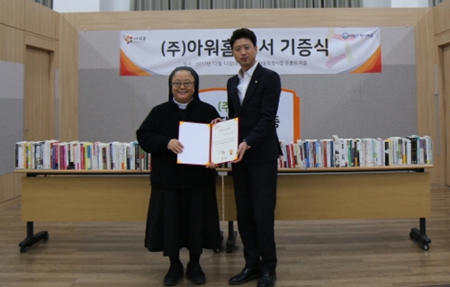 서울특별시립 은평의마을 도서관에서 진행된 도서 기증식 모습(왼쪽부터 은평의마을 이향배 원장, 아워홈 손세일 인력개발팀장)