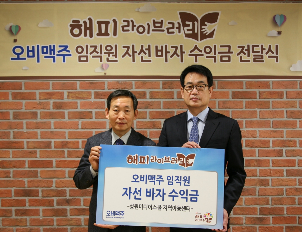 서울 강남 오비맥주 본사에서 오비맥주 장유택 부사장(오른쪽)이 ‘성원미디어스쿨 지역아동센터’ 임동채 센터장과 기부금 전달식을 마치고 기념촬영을 하고 있다. (사진=오비맥주)