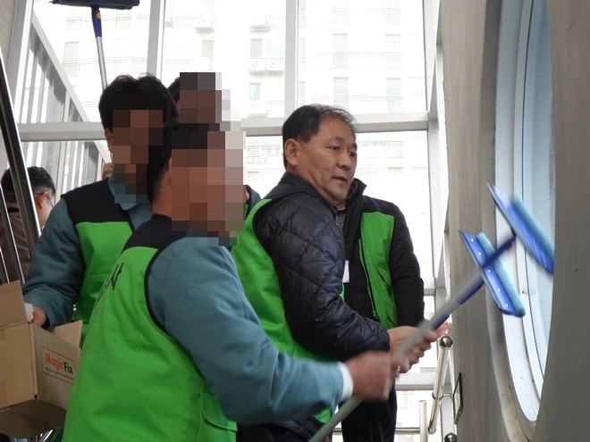 복지관 유리창을 청소하고 있다.(사진=부산구치소)