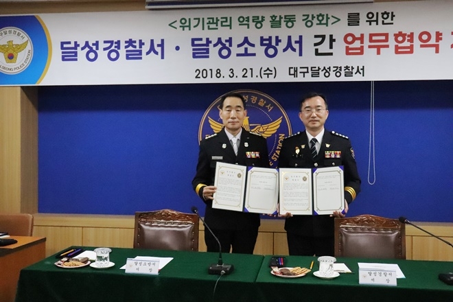 남은석 소방서장(사진왼쪽)과 오완석 경찰서장이 업무협약서를 내보이며 기념촬영을 하고 있다.(사진=대구달성경찰서〉