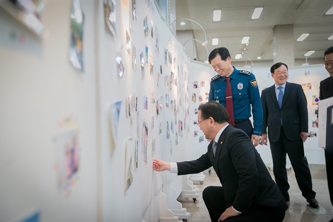 김부겸 장관이 부산청 직원 사진전시회를 보며 웃음짓고 있다.(사진제공=부산지방경찰청)