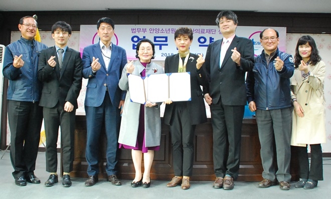 업무협약서를 내보이며 손사랑 표시로 기념촬영을 하고 있다.(사진=안양소년원)