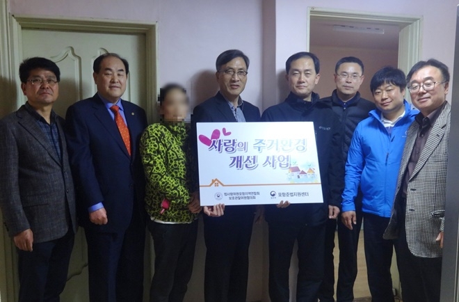 사랑의 주거환경개선 가정에서 공사를 마무리하고 기념촬영을 하고 있다.(사진제공=포항준법지원센터)