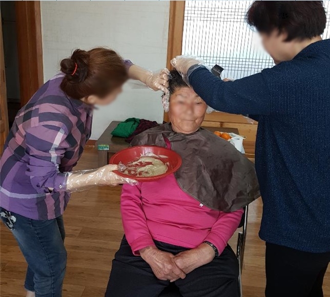 마을 어르신에게 염색서비스를 제공하고 있다.(사진제공=통영준법지원센터)