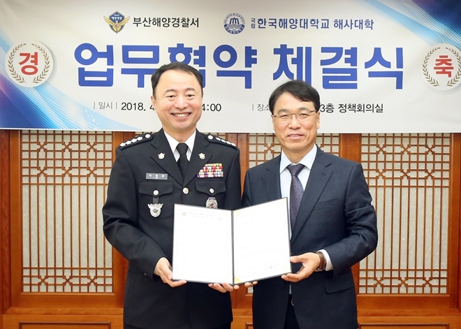 이명준 부산해양경찰서장, 이윤철 한국해양대 해사대학장이 협약서를 내보이며 기념촬영을 하고 있다.(사진제공=한국해양대)