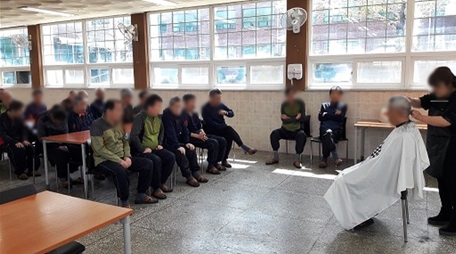 미용특기를 가진 사회봉사대상자가 장애인의 머리를 손질하고 있다.(사진제공=구미준법지원센터)