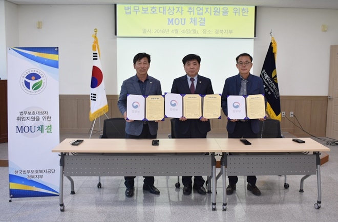 법무보호대상자 취업지원 업무협약서를 내보이며 기념촬영을 하고 있다.(사진제공=한국법무보호복지공단경북지부)
