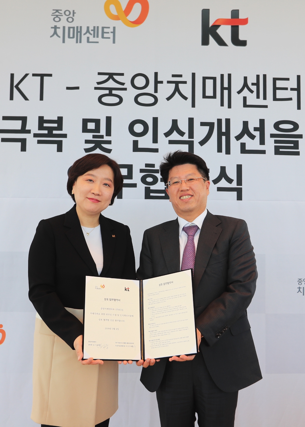 KT 지속가능경영단장 이선주 상무와 중앙치매센터 김기웅 센터장이 치매 극복 및 인식 개선을 위한 협약식을 맺고 기념촬영을 하고 있다. (사진=kt)