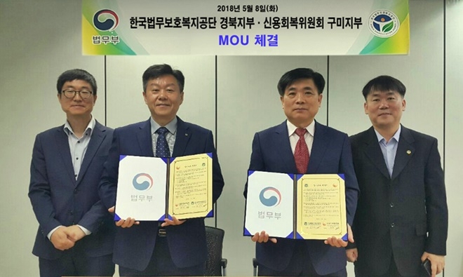 업무협약서를 내보이며 기념촬영을 하고 있다.(사진왼쪽 두번째 백상욱 지부장, 우측 두번째 김수진 지부장)(사진제공=한국법무보호복지공단경북지부)