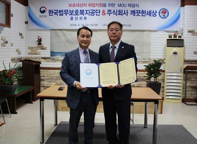 보호대상자 일자리창출 업무협약서를 내보이며 기념촬영을 하고 있다.(사진제공=한국법무보호복지공단 울산지부)