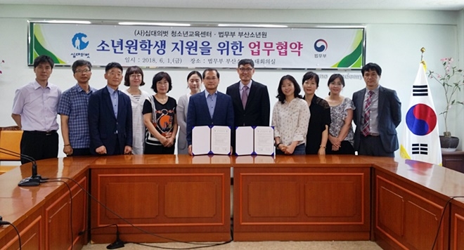 업무협약서를 내보이며 기념촬영을 하고 있다.(사진제공=부산소년원)