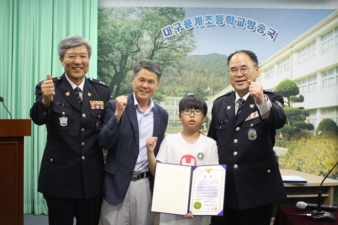 선행수범 초등학생에게 경찰서장 상장을 전달하고 기념촬영을 하고 있다.(사진제공=대구달성경찰서)
