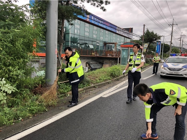 가로수 등 전지작업을 하고 주위를 청소하고 있다.(사진제공=창원서부경찰서)