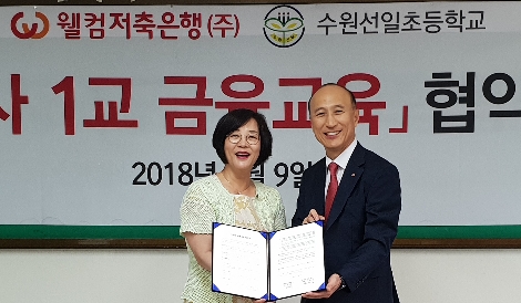 웰컴저축은행 김대웅 대표이사(오른쪽)와 수원선일초등학교 임경애 교장(왼쪽)이 기념촬영을 하고 있다. (사진=웰컴저축은행)