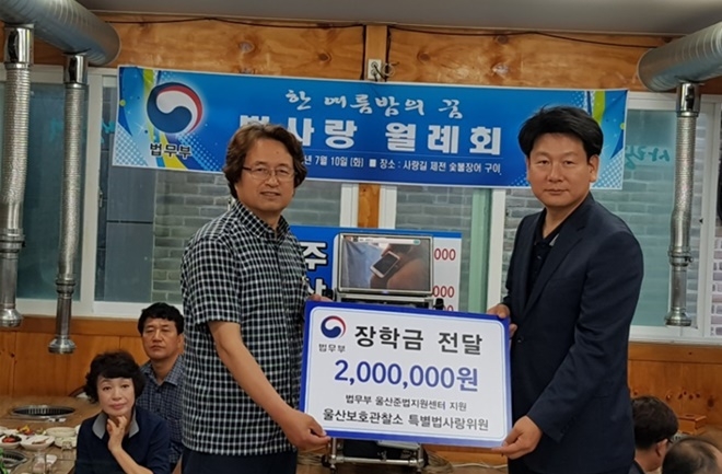 법사랑 정기월례회에서 권을식 소장(우측)에게 장학금을 전달하고 있다. (사진제공=울산준법지원센터)