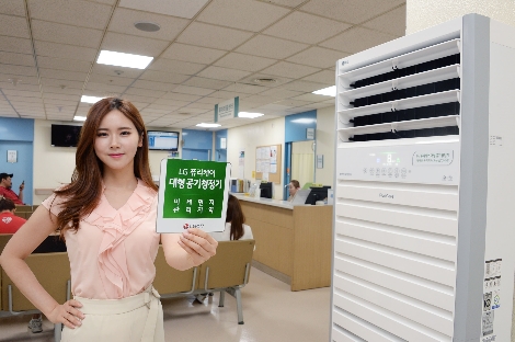 LG 퓨리케어 대형 공기청정기가 설치된 인하대병원에서 모델이 '미세먼지 관리지역' 스티커를 소개하고 있다. (사진=LG전자)