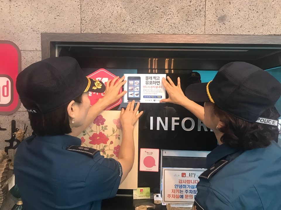 불법촬영 경고전단지를 부착하고 있다.(사진제공=창원서부경찰서)